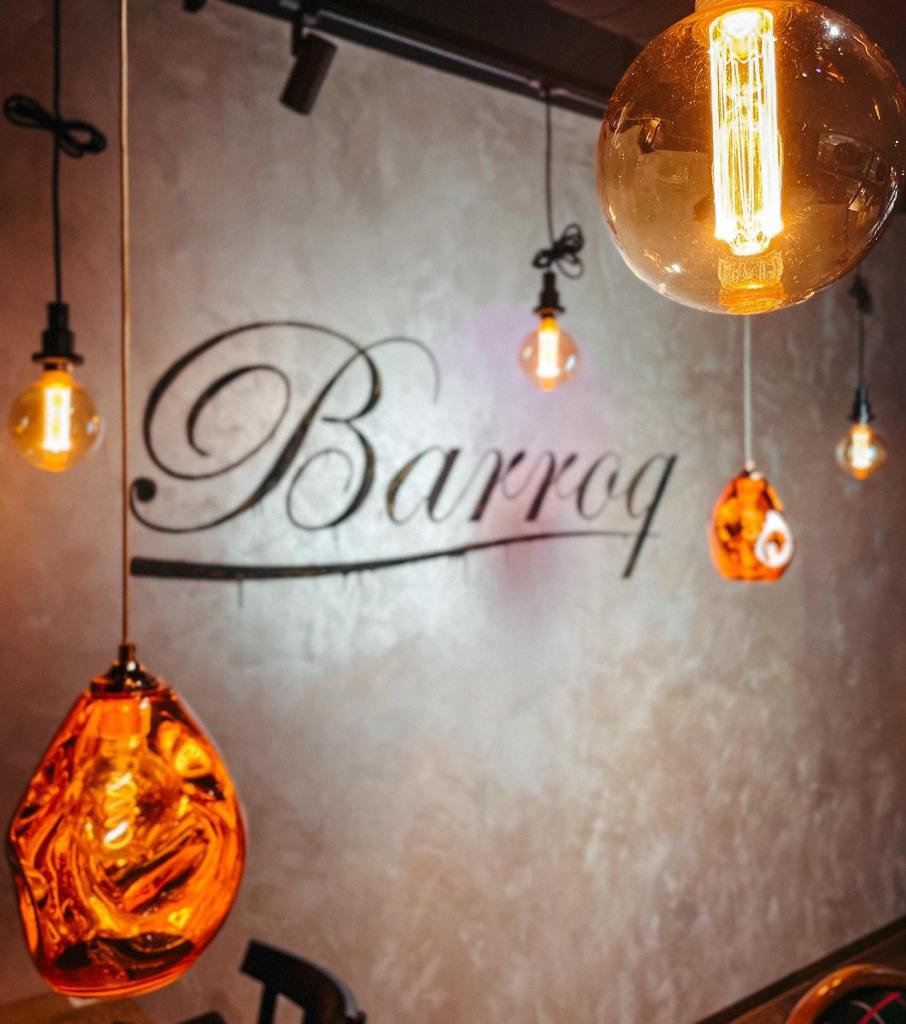 Warme Pendelleuchten und Barroq-Schriftzug im Restaurant